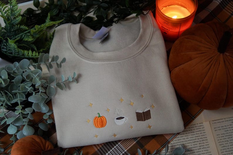 Autumn Icons Pullover Embroidered Jumper   Autumnal Sweatshirt   Fall Inspired Sweater   Pumpkin Coffee Cup And Book Autumn Design 1725954808868.jpg
