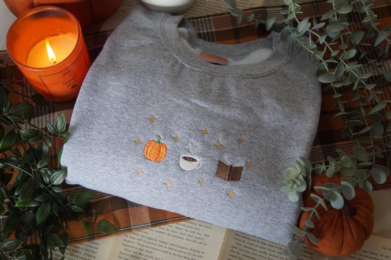 Autumn Icons Pullover Embroidered Jumper   Autumnal Sweatshirt   Fall Inspired Sweater   Pumpkin Coffee Cup And Book Autumn Design 1725954808988.jpg