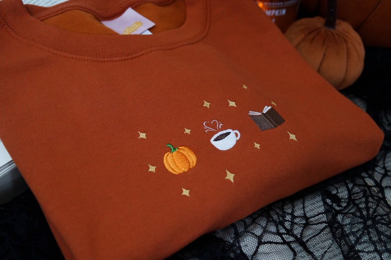 Autumn Icons Pullover Embroidered Jumper   Autumnal Sweatshirt   Fall Inspired Sweater   Pumpkin Coffee Cup And Book Autumn Design 1725954808992.jpg