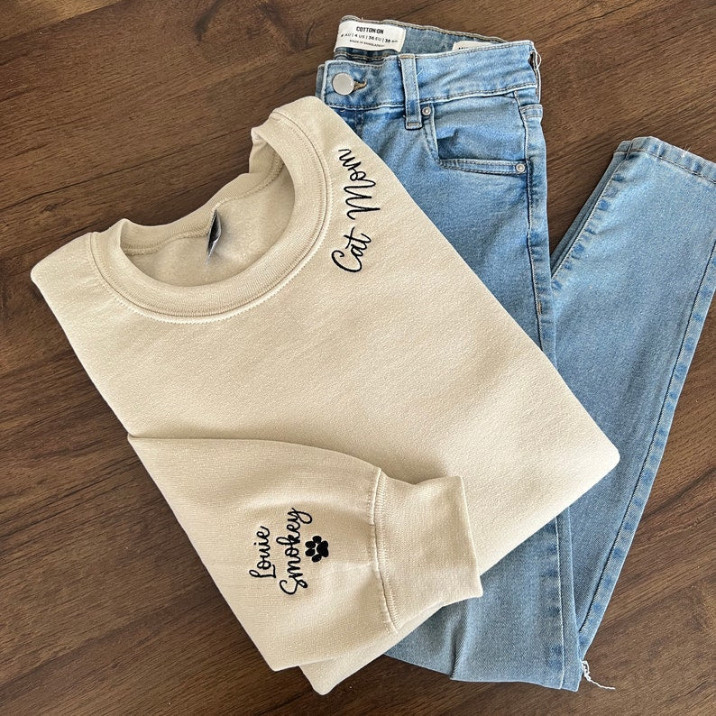 Cat Mom Embroidered Sweatshirt, Custom Mama Shirt With Pet Names, Cat Mom On Neckline, Paw On Sleeve, Gift For Cat Mom, Mother's Day Gift il_794xN.4785988086_q79p.jpg?v=1743397328