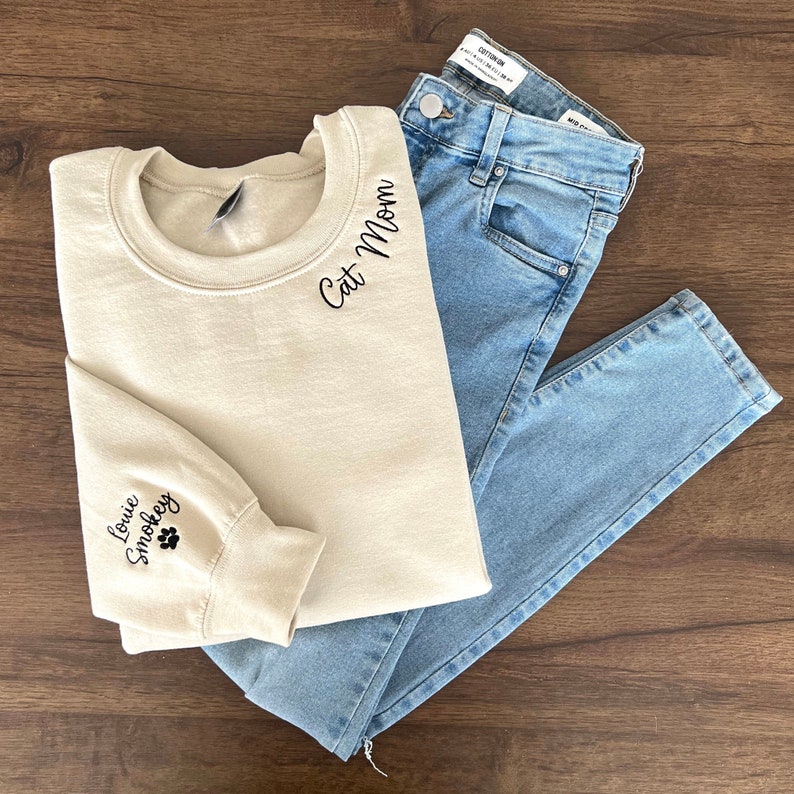 Cat Mom Embroidered Sweatshirt, Custom Mama Shirt With Pet Names, Cat Mom On Neckline, Paw On Sleeve, Gift For Cat Mom, Mother's Day Gift il_794xN.4834255097_f9z0.jpg?v=1743397328